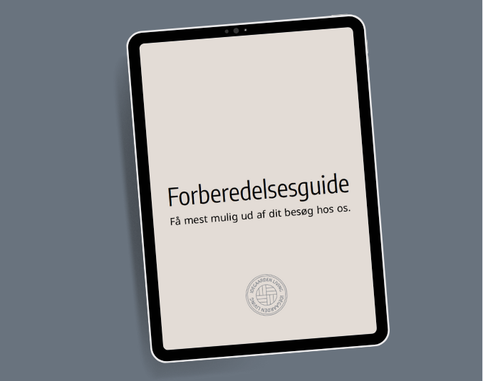To medarbejdere fra Idegaarden diskuterer et projekt foran en væg med marmorfliser.